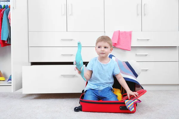 Söt liten pojke leker med resväska hemma — Stockfoto