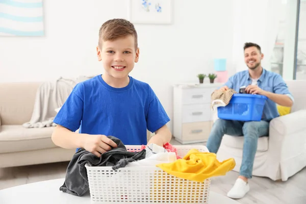 Lindo chico y su padre preparando ropa para lavar en casa — Foto de Stock