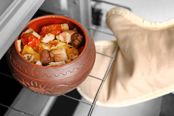 Hand checking pot with chicken ragout — Stock Photo, Image