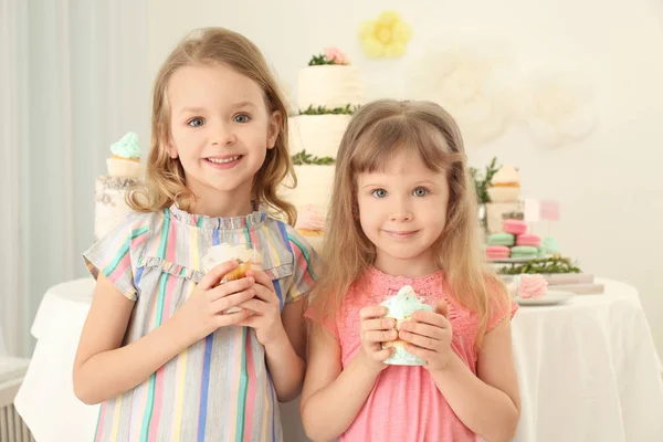 Söta flickor nära bord med sötsaker serveras för fest — Stockfoto