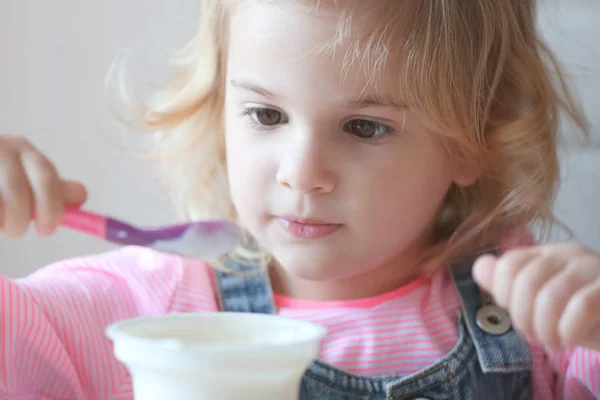 Niña comiendo yogur — Foto de Stock