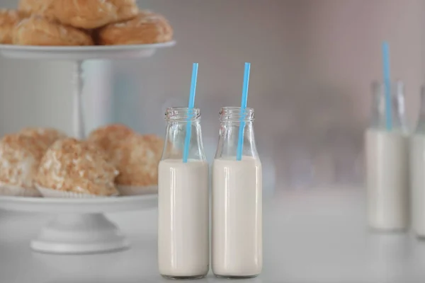 Tabel met flessen van melk en dessert staan — Stockfoto