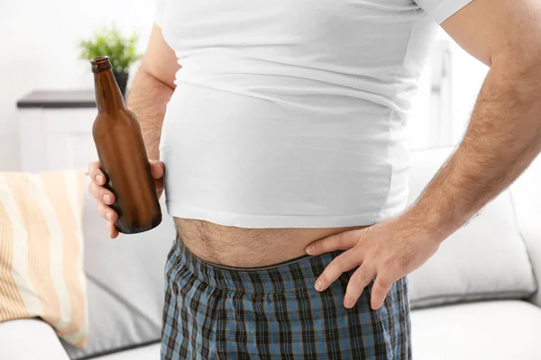 Man with big belly holding beer