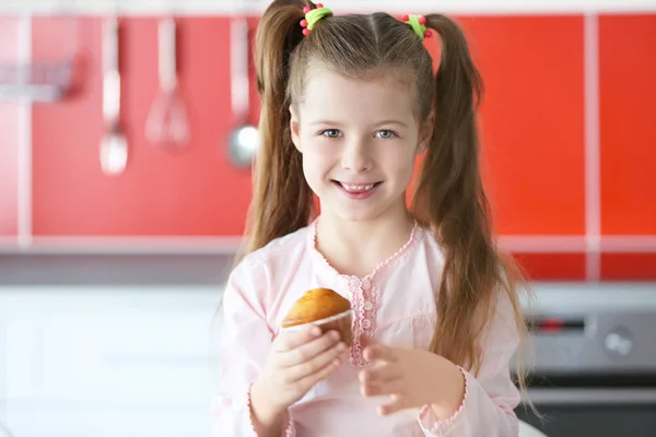 Kleines Mädchen mit leckerem Muffin — Stockfoto
