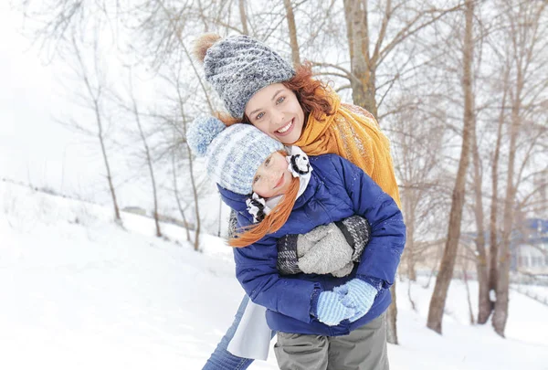 Matka z córką, grać w winter park — Zdjęcie stockowe