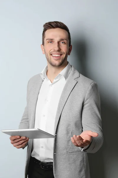 Ung vacker man med surfplatta på ljus bakgrund — Stockfoto