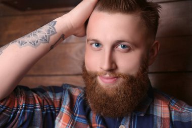 Sakallı adam ahşap arka plan üzerinde poz