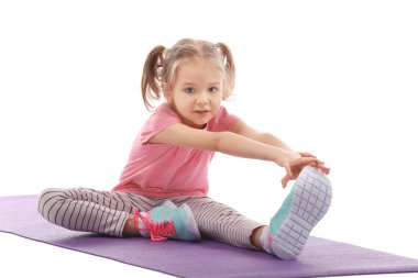 Sevimli kız mat, üzerinde beyaz izole jimnastik egzersizleri yapıyor