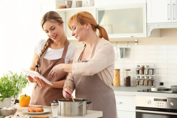 Mujer joven y su madre cocinando en la cocina —  Fotos de Stock