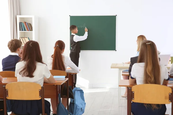 Schooljongen beantwoorden op een schoolbord in de klas — Stockfoto