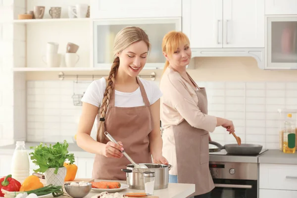 Giovane donna e sua madre che cucinano in cucina — Foto Stock