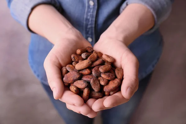 Manos femeninas sosteniendo granos de cacao aromáticos —  Fotos de Stock