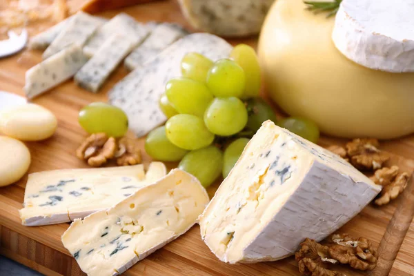 Нарезанный сыр с виноградом и орехами — стоковое фото