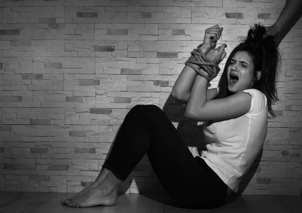 Junge Frau mit gefesselten Händen im Zimmer Gewalt ausgesetzt — Stockfoto