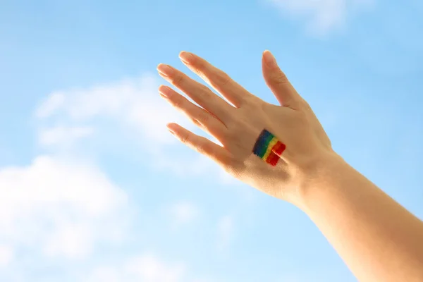 Mano femminile con bandiera arcobaleno dipinta — Foto Stock