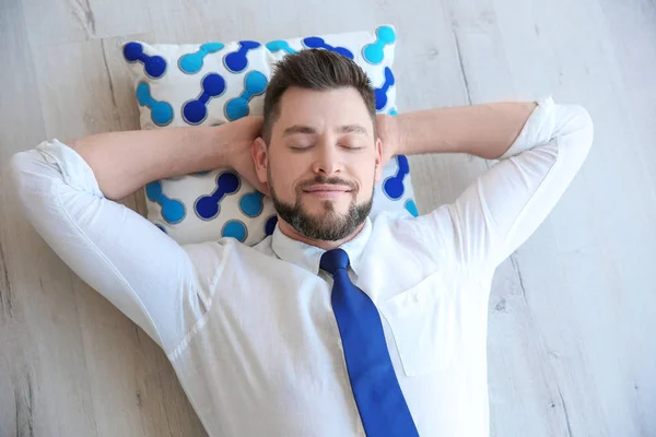 Gelukkig jongeman op vloer liggen en rusten — Stockfoto