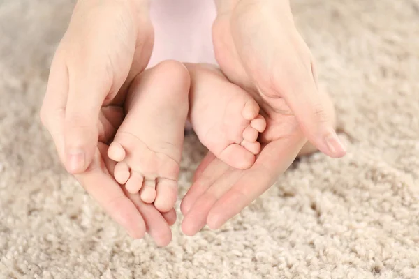 Pies de bebé en manos femeninas —  Fotos de Stock