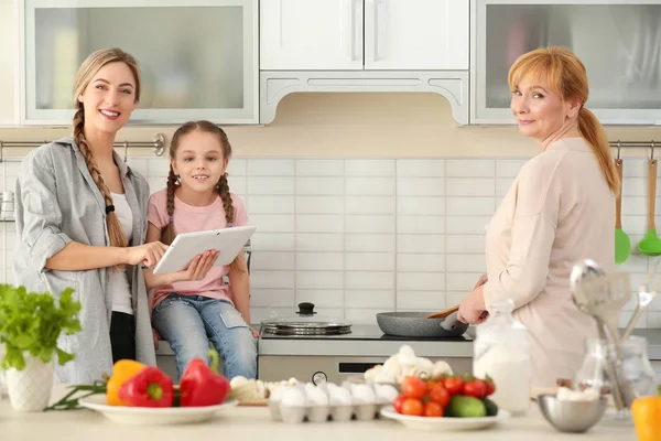 Молода жінка з дочкою і матір'ю на кухні — стокове фото