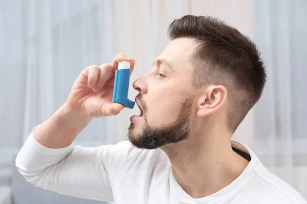 Jonge man met behulp van astma-inhalator — Stockfoto