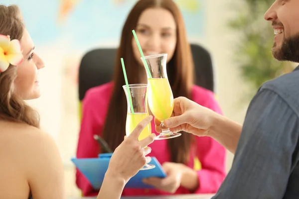 Adventure concept. Young couple drinking cocktails while visiting travel agency