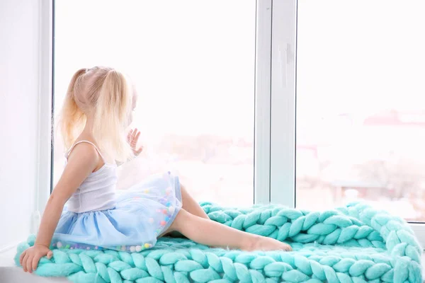 Little girl sitting on windowsill — Stock Photo, Image