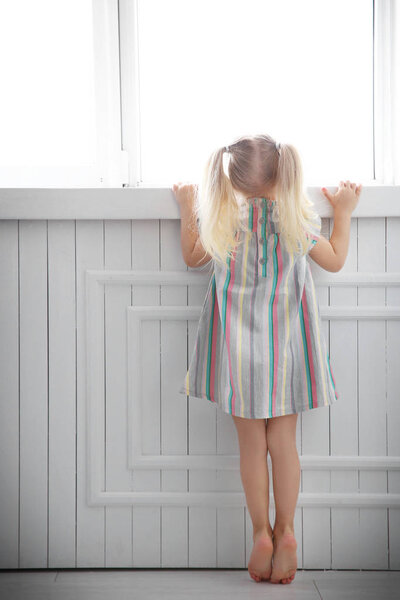 girl standing near window