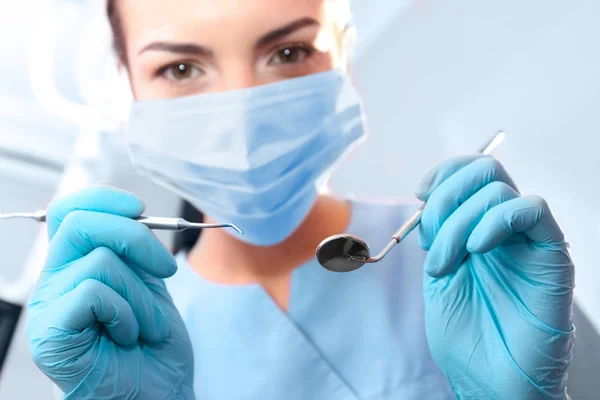 Dentista sosteniendo espejo y explorador periodontal en clínica — Foto de Stock