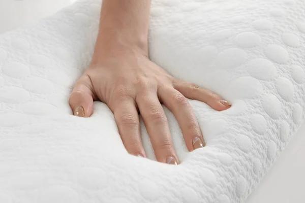 Mão feminina no travesseiro ortopédico — Fotografia de Stock