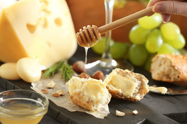 Woman pouring honey on bread