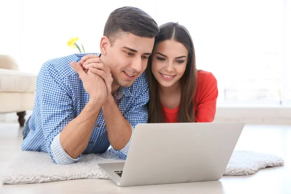 Счастливая молодая пара с ноутбуком — стоковое фото