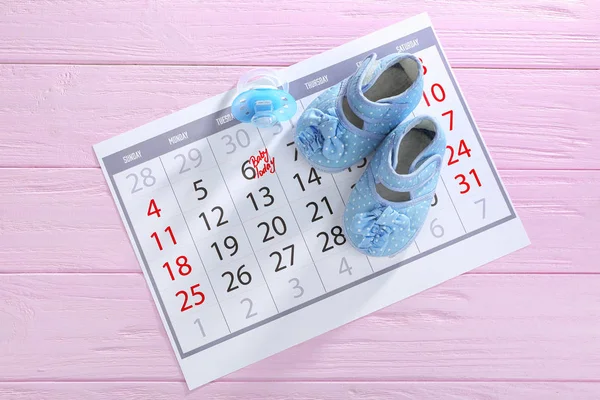 Calendário com botas de bebê — Fotografia de Stock