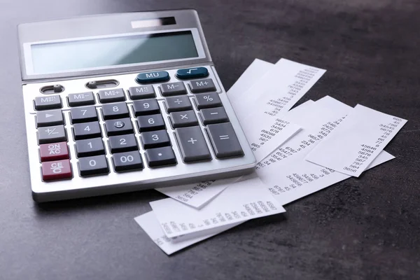 Calculator met rekeningen op grijze achtergrond — Stockfoto