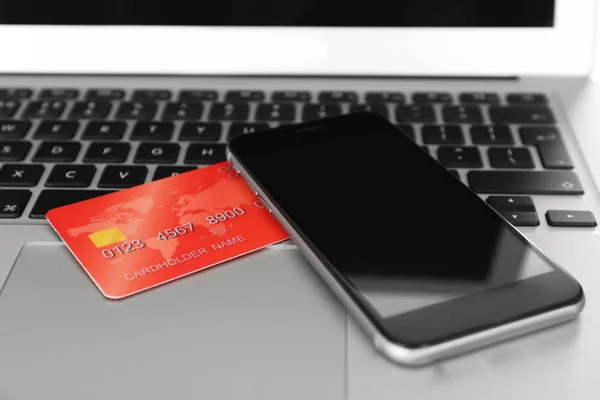 Кредитна картка і смартфон на клавіатурі — стокове фото
