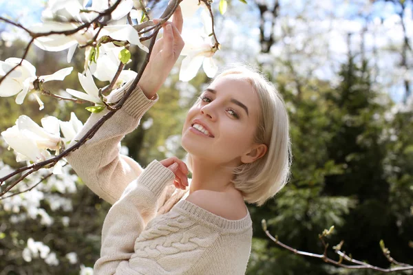 Jonge vrouw in de buurt van bloeiende Magnoliaboom — Stockfoto