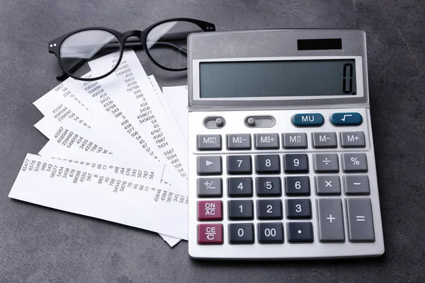 Calculator with bills on gray background — Stock Photo, Image