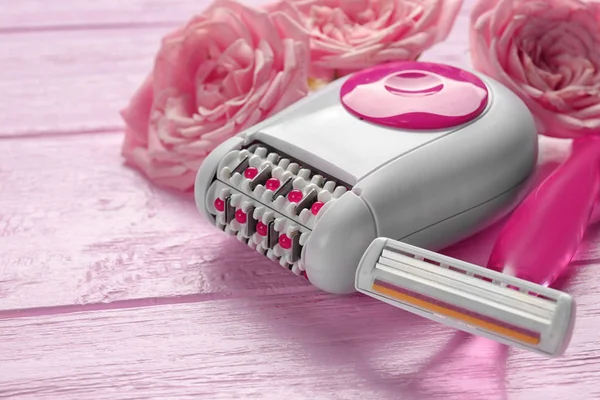 Epilator, scheerapparaat en bloemen — Stockfoto