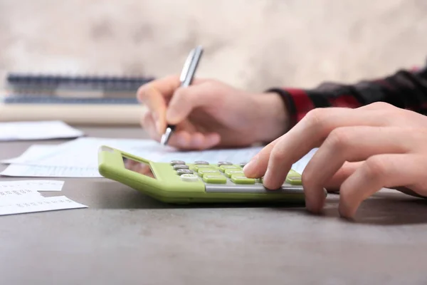 Hombre trabajando con documentos y calculadora —  Fotos de Stock