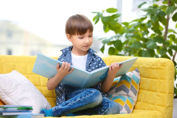 Söt liten pojke läser bok hemma — Stockfoto