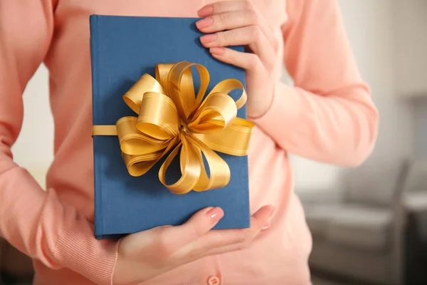 Vrouw met boek met lint als geschenk — Stockfoto