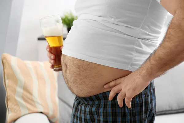 Uomo con grande pancia contenente birra — Foto Stock