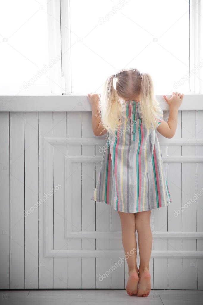 girl standing near window