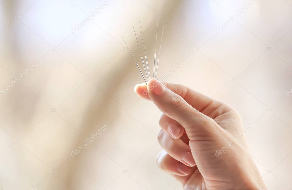 Female hand with needles for acupuncture