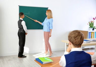 Kadın öğretmen ve öğrenci sınıfta blackboard