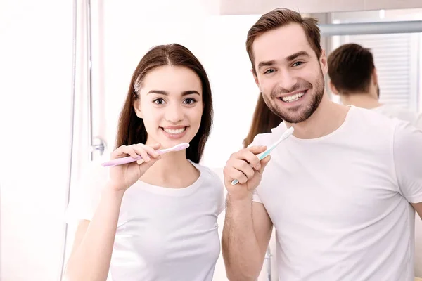 Pareja joven cepillándose los dientes — Foto de Stock