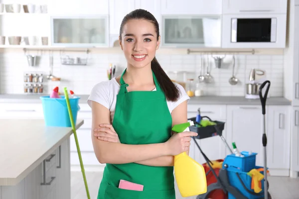 Junge Arbeiterin mit Flasche Waschmittel in der Küche — Stockfoto