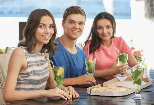 Amigos felizes comendo pizza no café — Fotografia de Stock