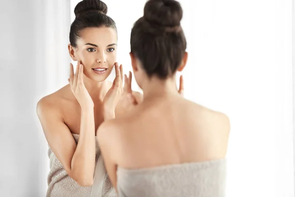 Beautiful woman looking in mirror — Stock Photo, Image