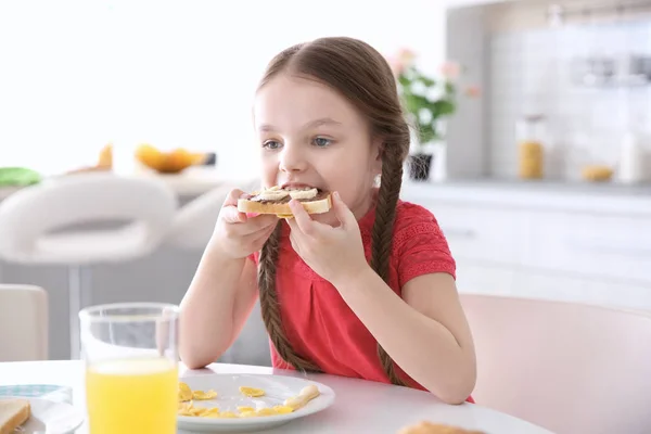 Sød lille pige, der spiser morgenmad derhjemme - Stock-foto