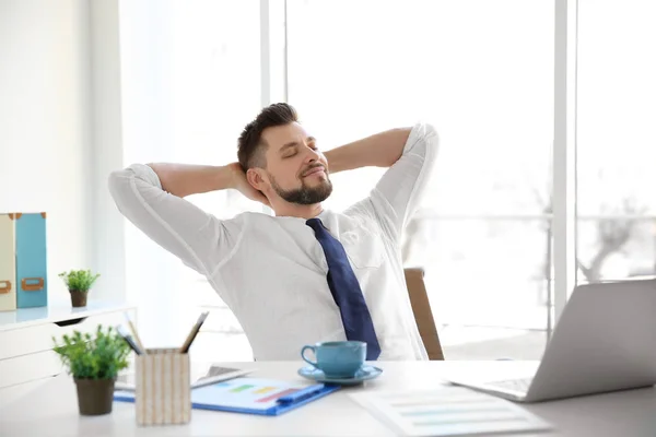 Relaxed young man sitting at table