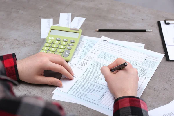 Man aan het werk met documenten en calculator — Stockfoto